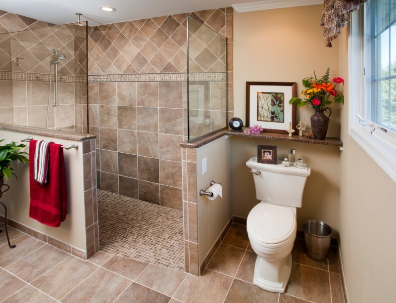 bathroom with walk in showers without door with brown tiles wall up to ceiling, half way wall with brown tiles in the bottom and glass partition in the bottom