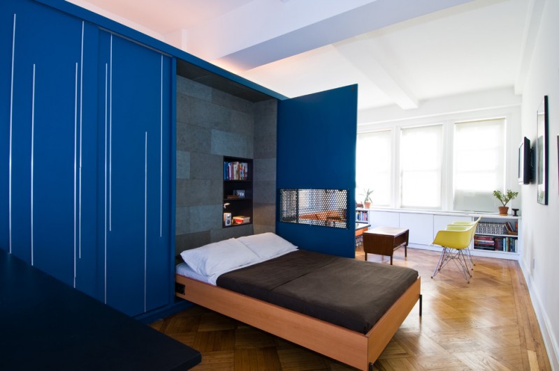 brown wooden unfolding bed with blue door storage cupboard, built in shelves on headboard