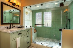 craftsman bathroom with shower are in green tiles floor, green tiles wall, green marble ceiling, sink area with brown walls, green cabinet with grey marble top, mirror