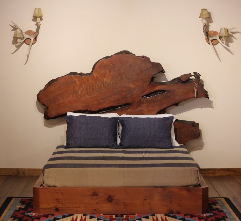modern rustic bed design idea with unique log cut headboard multicolor area rug with modern motif dark toned wood floors light cream walls