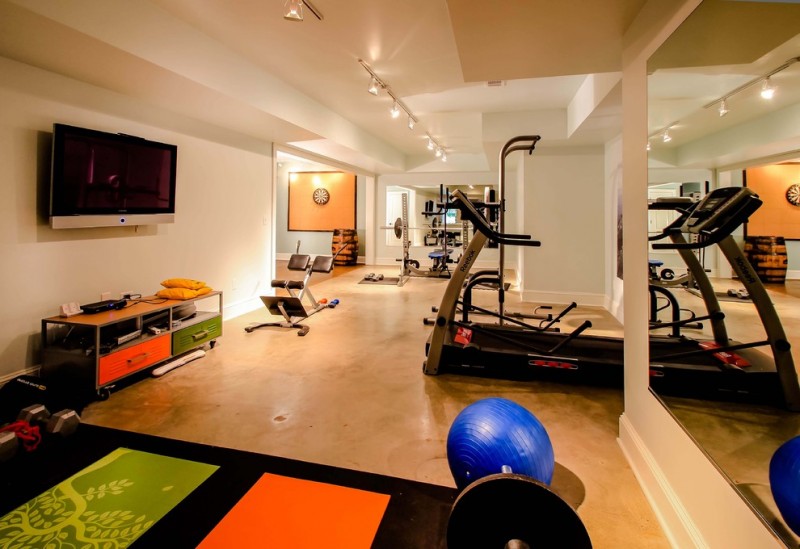 nicely designed basement floors concrete floor home gym wall tv fitness equipment carpet ceiling lamps