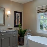bathroom color trends beaded inset cabinets freestanding tub alcove shower undermount sink mirror granite countertop porcelain floors beige walls hanging lamps traditional design