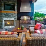 Mid Sized Classic Backyard Patio Design With A Fire Feature, A Roof Extension And Natural Stone Pavers Rattan Framed Sofa Pillow Throws Coffee Table