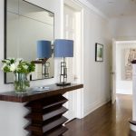 Modern Entryway Table Stairs Railing Hardwood Floors Lamp Mirror Glass Vase Door Framed Painting Transitional Design