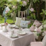 tea party decoration ideas triangle flags pink and white stripe table cloth antique wooden chairs with pastel colors cushions