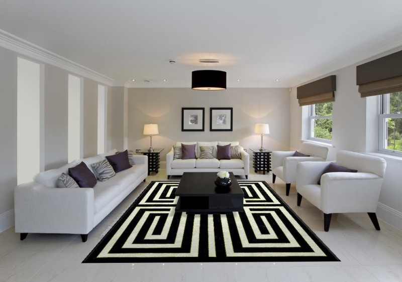 modern living room soft white sofas with accent pillows two white chairs modern black coffee table with decorative vase monochromatic area rug white floors light grey walls