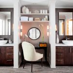 traditional bathroom with two separated white marble top vanity with white sinks, brown wooden cabinet, separated with shelves and makeup counter