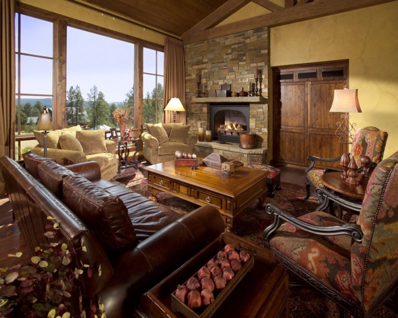 Huge tuscan formal and open concept medium tone wood floor living room with a standard fireplace, a stone fireplace, yellow walls and a concealed tv
