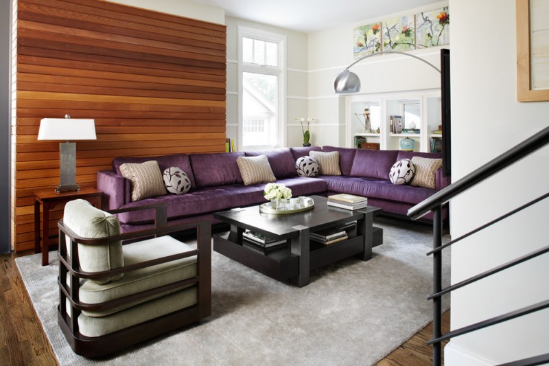 purple sofa armchair beadboard black coffee table floor lamp horizontal wood paneling grey rug steel railing wood floor wooden side table table lamp