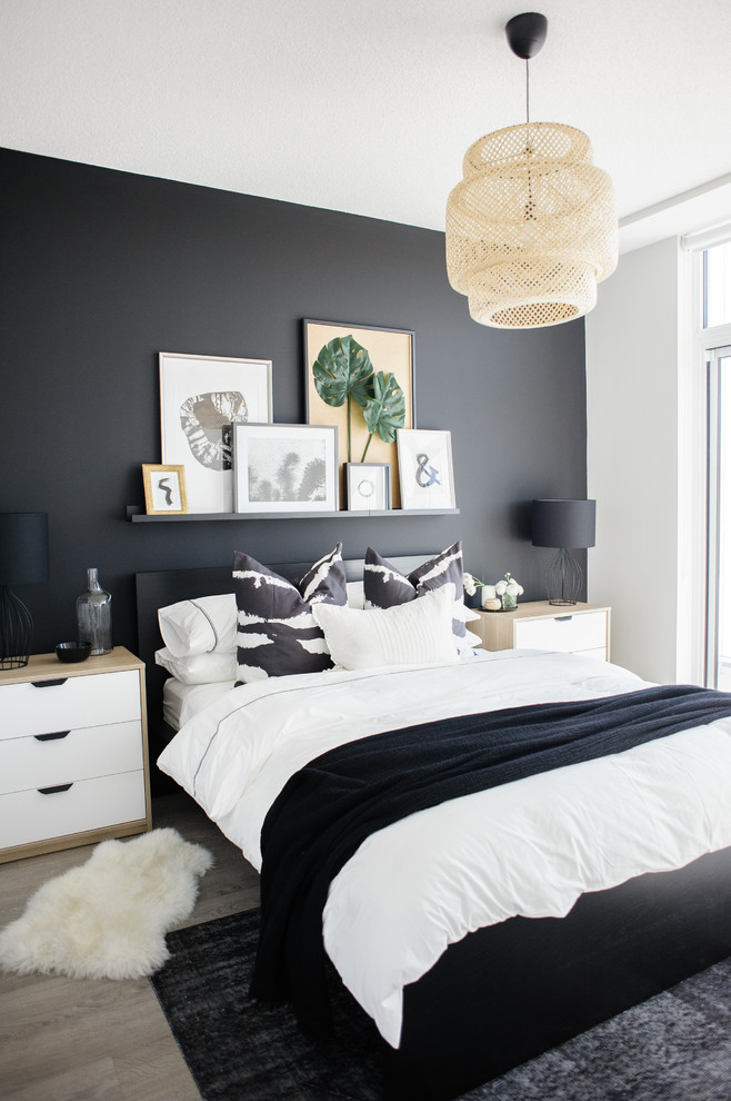 black bedroom beige pendant light black accent wall framed art gray rug black throw white nightstands black table lamps
