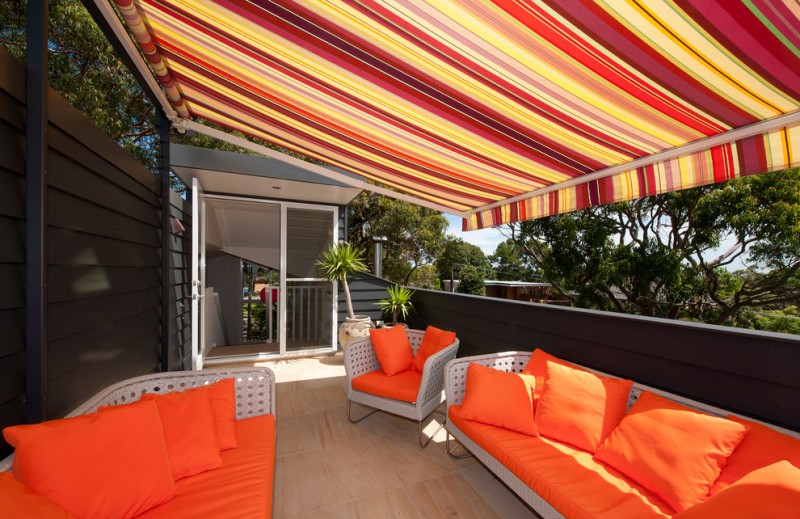 modern awning bright colours covered deck glass door orange outdoor cushions orange throw pillows outdoor furniture