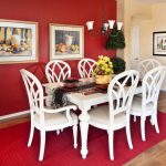 Red Dining Room Red Wall Red Rug White Dining Table And Chairs Artwork Wood Flooring Chandelier Indoor Plants Flowers Arrangement