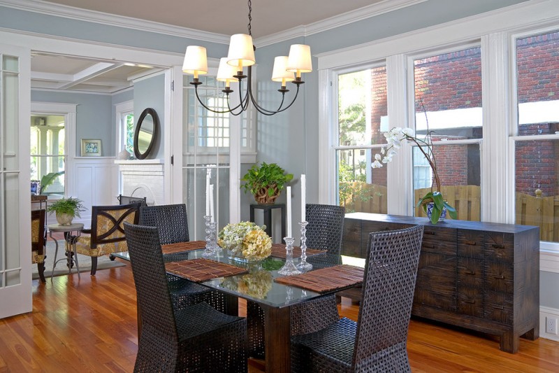 square pedestal table baseboards chandelier crown molding black chairs french doors orchid potted plants wood floor