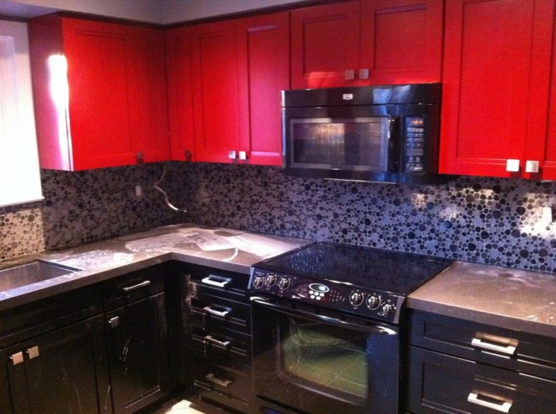 red and black kitchen red top cabinets black cabinets stovetop microwave oven backsplash countertop sink window