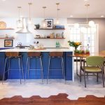 Kitchen With Wooden Floor, White Tiles, Blue Wooden Island With White Top, Half Round Dining Table With Wooden Chairs, Hanging Lamps