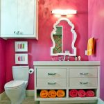 Over The Toilet Storage Pink Walls Vanity Undermount Sink White Framed Mirror Towel Holder White Wall Mounted Cabinet Brown Floor Tile Wall Sconce