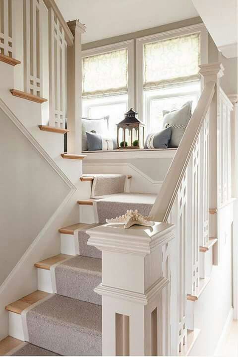 white and brown stairs with rug, seating in window sill