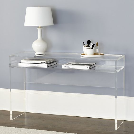 console table with clear acryllic, books, white table lamp