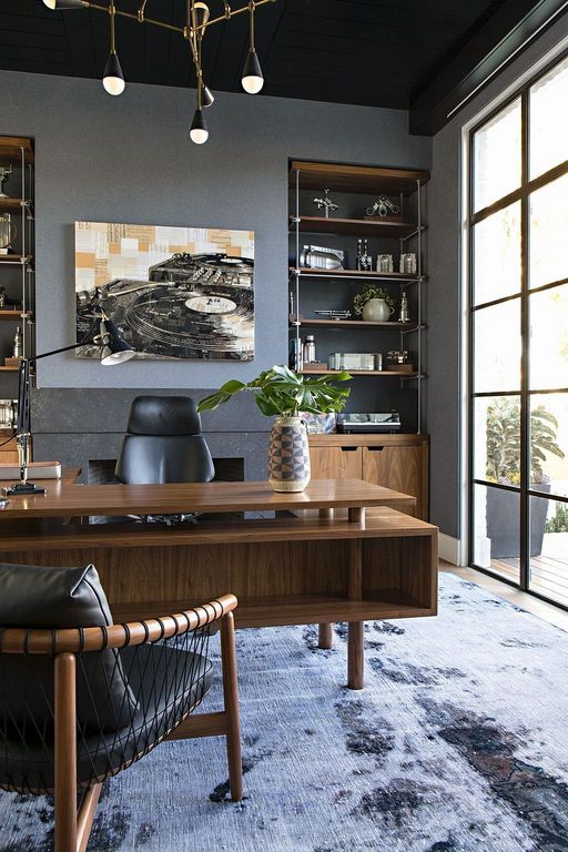 home office with wooden floor, large rug, wooden table, wooden chairs with leather cushion, wooden shelves