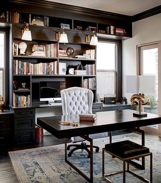 home office with wooden floor, rug, black wooden table with stool, white high back chair, black bookshelves