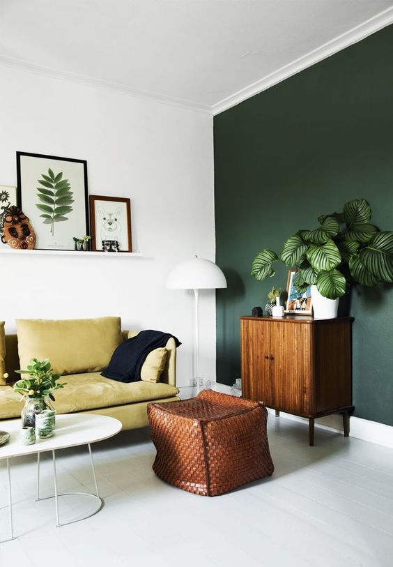 living room, white floor, white wall, green wall, green sofa, white coffee tbale, leather woven ottoman, wooden cabinet, white floor lamp, white floating shelves