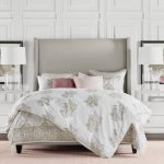 Bohemian Duvet Cover White Walls Frames Glass Table Lamps White Shades White Nightstands White Bedding Pink Rug Wooden Floor Beige Headboard Drawers