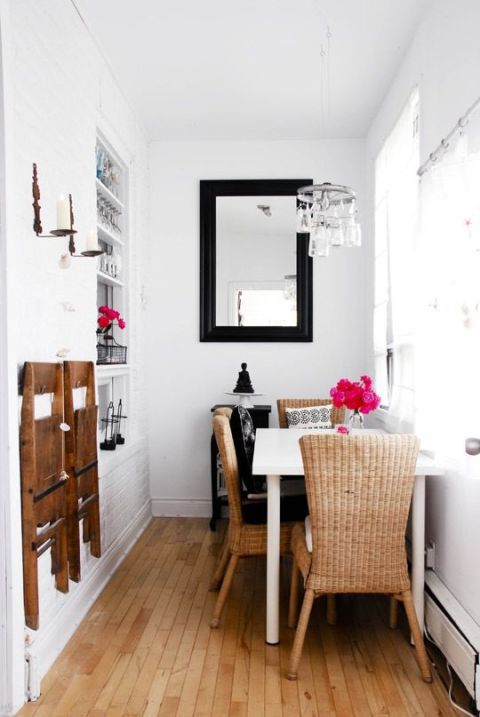 white wooden table, rattan chairs with tall back, wooden floor, white wall, small chandelier