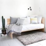 Wooden Daybed With Cornered Back, White Cushion, Pillows, Grey Rug