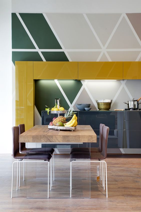 kitchen, wooden floor, patterned wall tiles, yellow gloss upper cabinet, grey bottom cabinet, wooden table, brown chairs