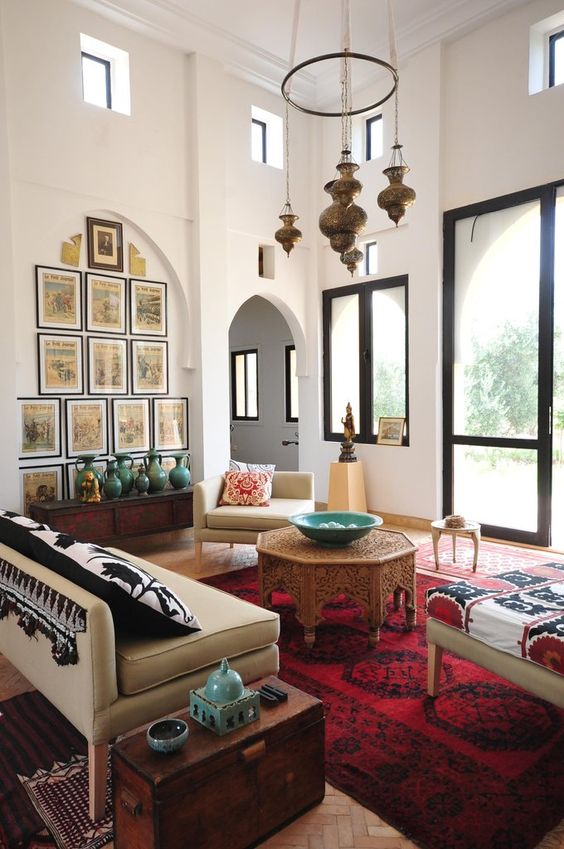 moroccan styled chandelier, white wall, white sofa, red rug, moroccan detailed coffee table, arch wall, glass door