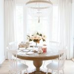 Round Wooden Dining Table, White Wooden Chairs, Chandelier, White Ceiling, Wooden Floor, White Curtain