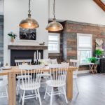 Rustic Dining Table Industrial Pendant Lamps White Chairs Black Fireplace Windows Shades Mantel Beams