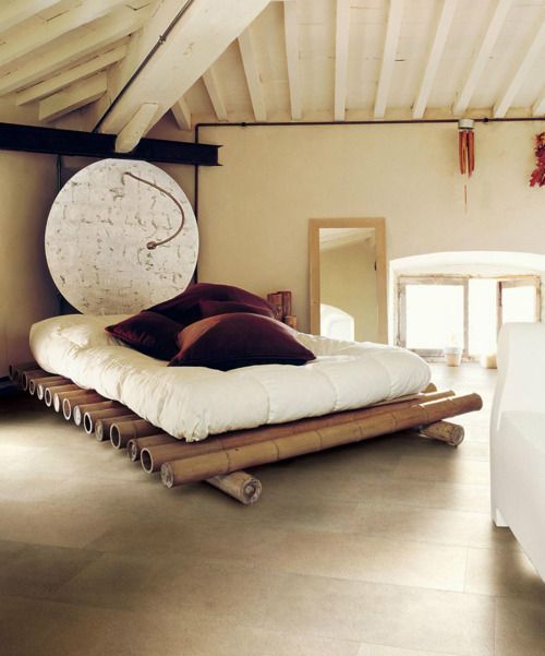 bamboo bed platform, brown floor tiles, white wall, white wooden beams, white cushion