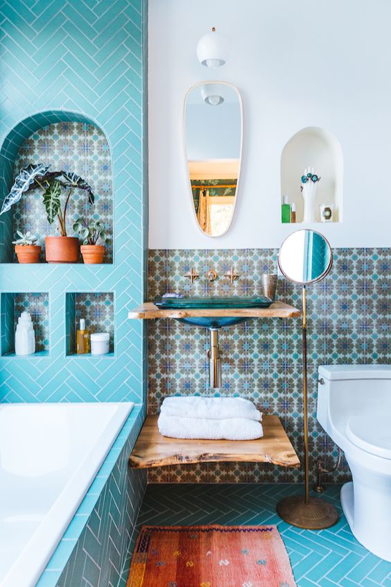 bathroom, blue floor tiles, whte wal, blue patterned wall, wooden floating snk, white toilet,