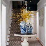 Foyer, White Wall, Dark Blue Ceiling, Crystal Chandelier, White Wooden Roun Table With Black Top, Wooden Floor, Rug