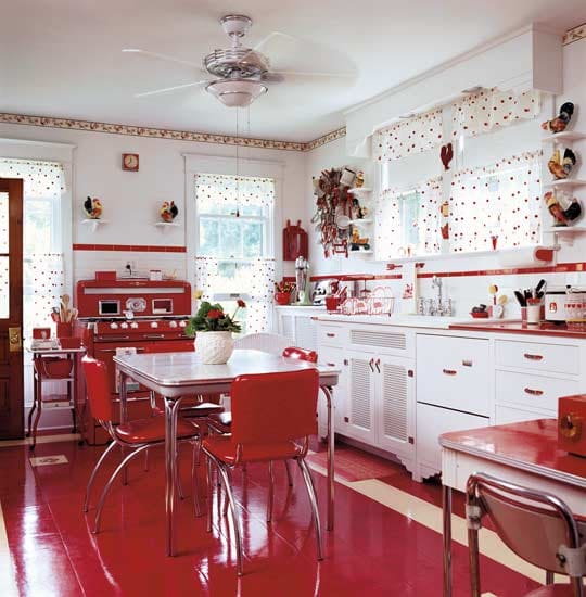kitchen, white cabinet, white backsplash, white wall, white floating small shelves, red accent, white curtain with red dots, red floor, white dining table, red chairs