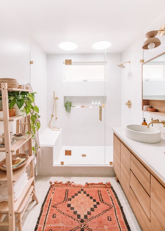 bathroom, white bathroom, wooden cabinet with white top, white round sink, wooden shelves, white tiles, indented wall, rug