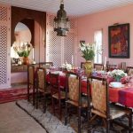 Dining Room, Herringbone Floor, Pink Wall, Ret Rug, White Rug, Red Table, Rattan Chairs, Moroccan Pendant