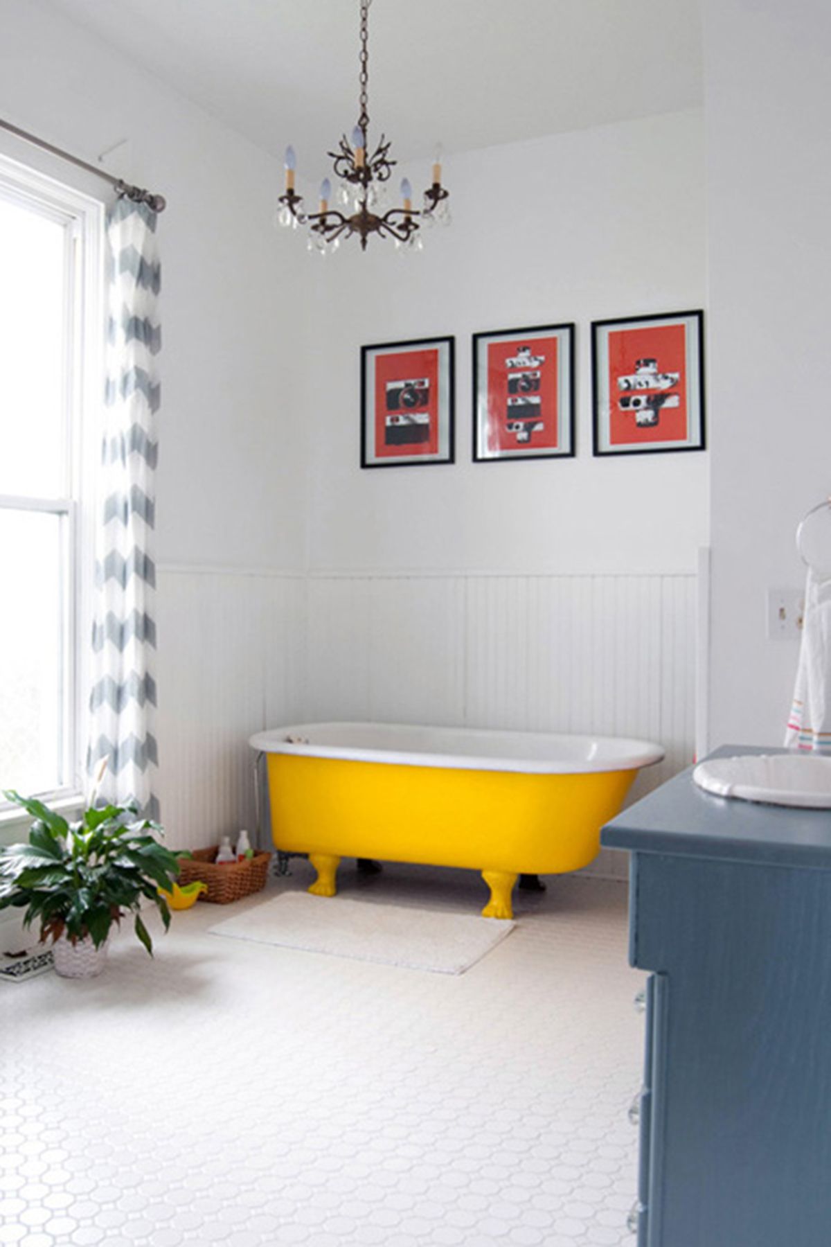 bathroom, white floor tiles, white wall, yellow tub, blue cabinet, white sink, white wainscoting wall