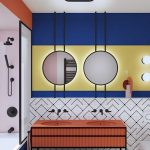 Orange Vanity Table, Indented Sink, White Patterned Wall, Blue Yellow Wall, Round Mirrors