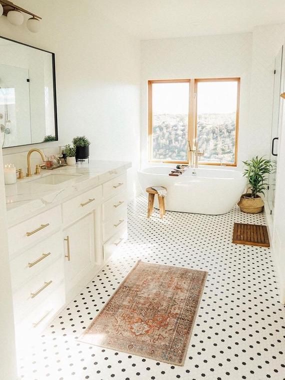 bathroom, white wall, white tub, wooden framed, white cabinet, white marble counter top, white small floor tiles, mirror