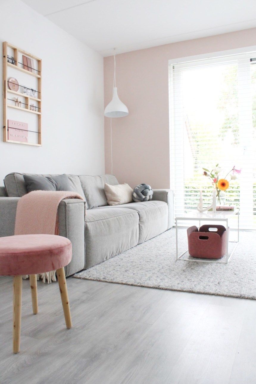 living room, grey floor, pink white wall, white pendant, grey sofa, pink velvet ottoman, white coffee table