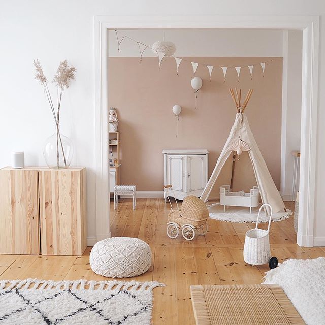 playroom, wooden floor, white wall, brown wall, wooden cabinet, white woven ottoman, white patterned rug, rattan rug, white wooden cabinet, white tent, rattan toys