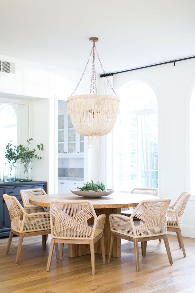 dining set, wooden floor, white wall, wooden chairs, round wooden table, white fringed chandelier