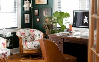 home office, wooden floor, green wall, wooden table, brown leather chair, rattan chair with flowery cushion