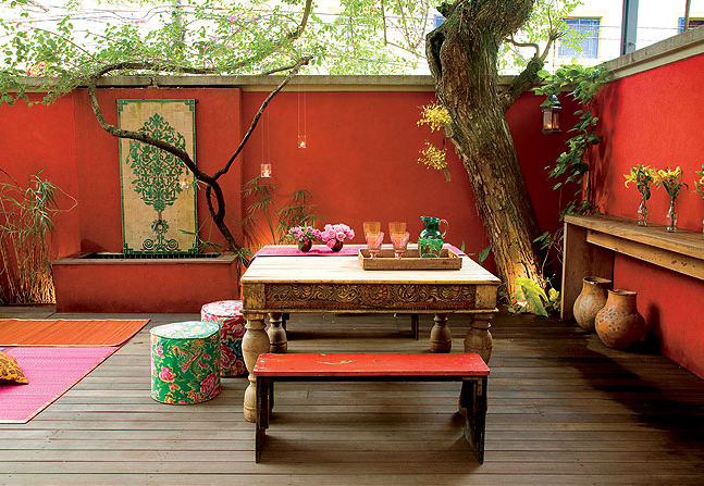 patio, orange wall, wooden floor, wooden table, wooden bench, trees