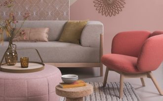 living room, grey rug, pink accent wall, pink round ottoman, red chair, grey sofa, pendant