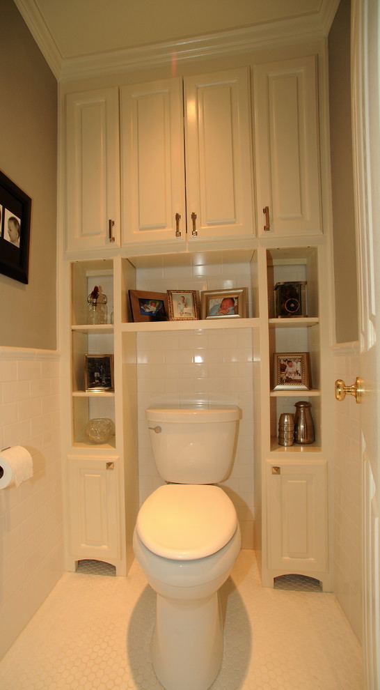 bathroom with white wall, white toilet, white shelves and white cabinet surrounded the toilet from the top