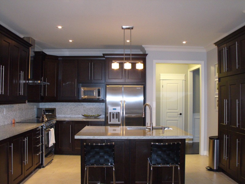 contemporary with dark cabinet, dark island with white counter top, white pendant, blue navy chair