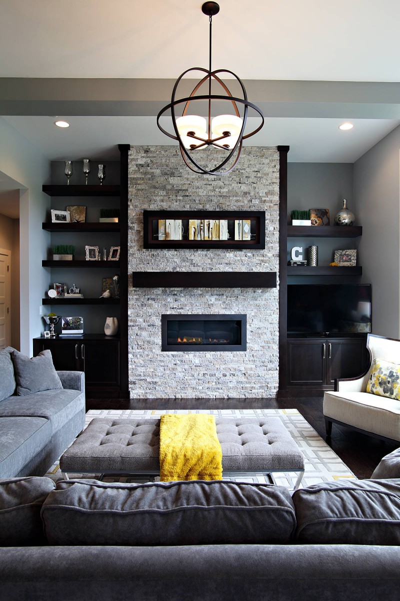 dark hardwood floor grey sofa modern pendant light brick fire place wall open floating shelves